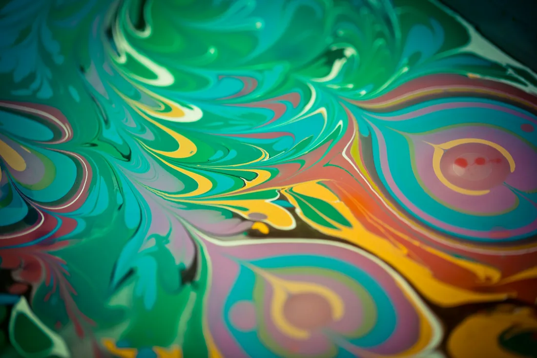 Superficie de un baño de marmolado con vetas de color arrastradas en ondas regulares